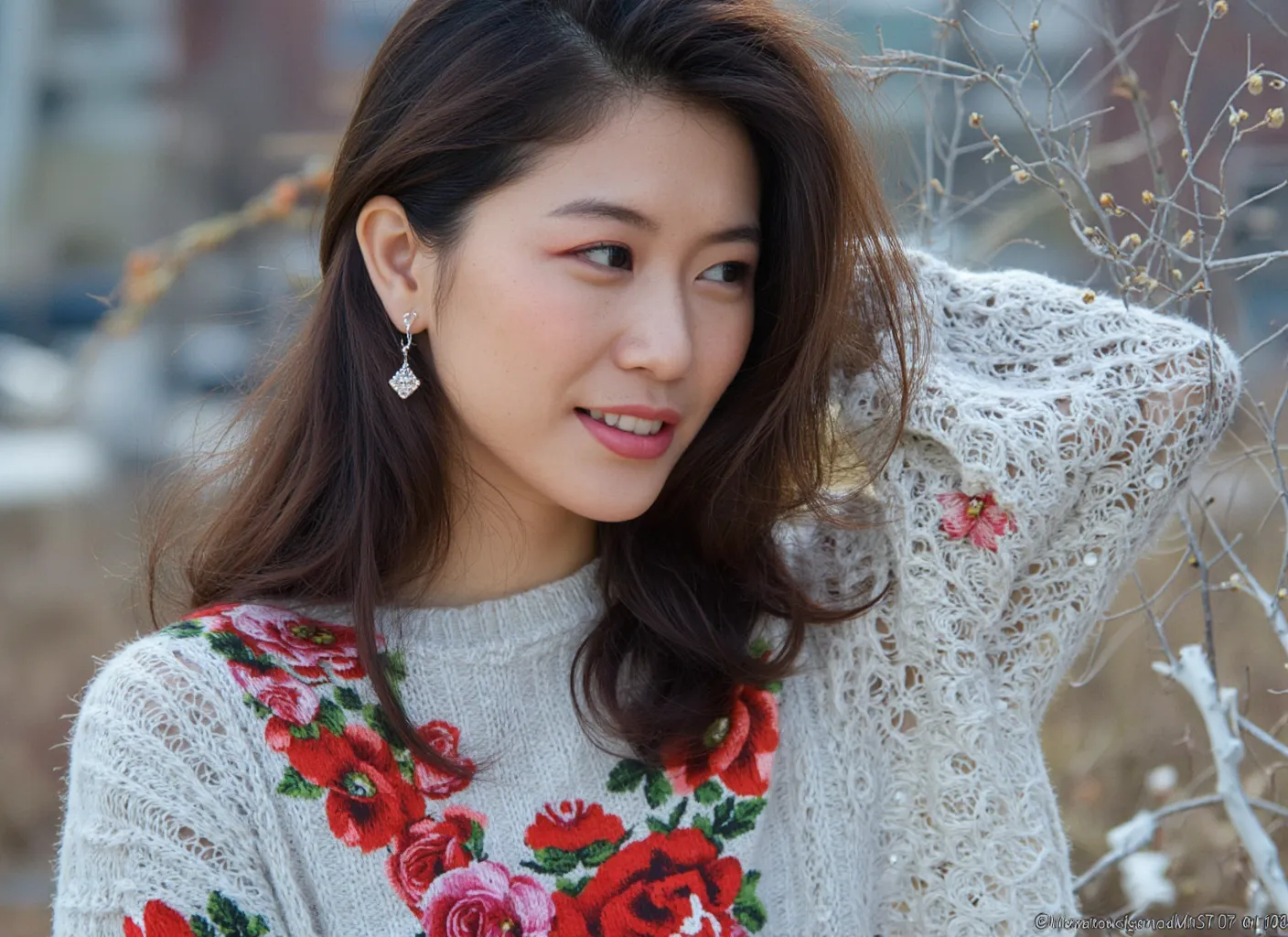Close-up high definition photo of an Asian model with flawless skin and a slight smile wearing a sweater with floral embroidery, outdoors.