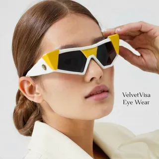 Close-up of a woman wearing stylish triangular sunglasses with yellow and white accents, showcasing a luxurious and high-end design.