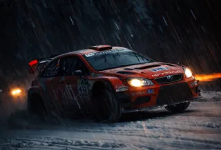 Un coche de rally WRC carmesí atraviesa a gran velocidad un bosque nevado de noche con fuerte nevada y faros cálidos que cortan la oscuridad.