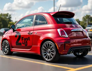 Sporty red Fiat 500 compact car with tinted windows, polished wheels, aftermarket spoiler, and black '2 Fast 4U' decal parked in a parking lot.