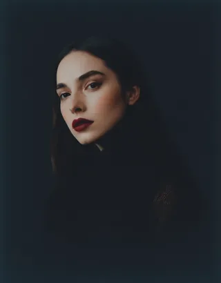 A close-up portrait of a beautiful young woman with dark lips and dramatic lighting, showcasing realism and an intimate, artistic expression.