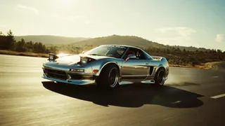 Chrome Honda NSX drifting on a highway with strong film grain effect and high contrast lighting creating dramatic shadows.