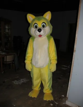 Person wearing a yellow and green anthropomorphic wolf fursuit standing in a dark, abandoned house illuminated by a flash, with grainy and low-quality photo effect.
