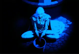 Brooding male figure Griffith sitting cross-legged by a well in a shaded courtyard with cobblestone ground, illuminated by dramatic blue lighting.